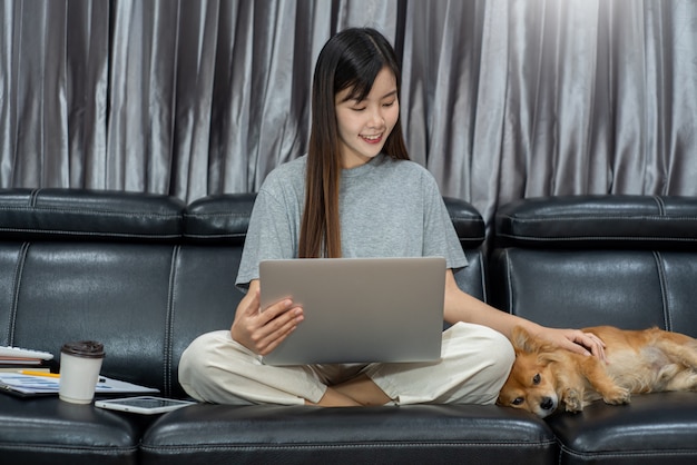 Joven hermosa mujer asiática trabajando en casa con su mascota