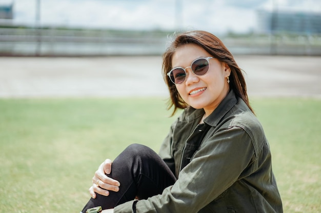 Joven hermosa mujer asiática vestida con chaqueta y jeans negros posando al aire libre