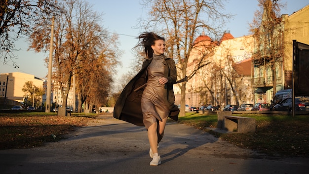 Foto joven hermosa mujer camina expresivamente en el parque.