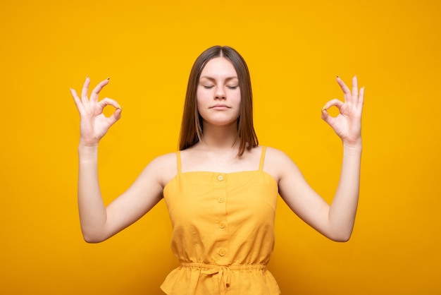 Joven hermosa mujer caucásica en un suéter amarillo sobre un amarillo