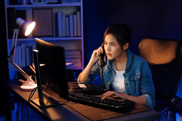 Joven hermosa mujer creativa asiática llamando en la mesa de teléfono Stratagem
