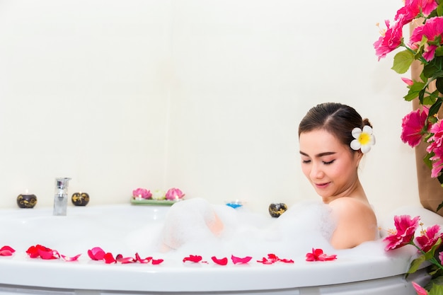 Foto joven hermosa mujer disfrutando en la bañera en el salón de spa