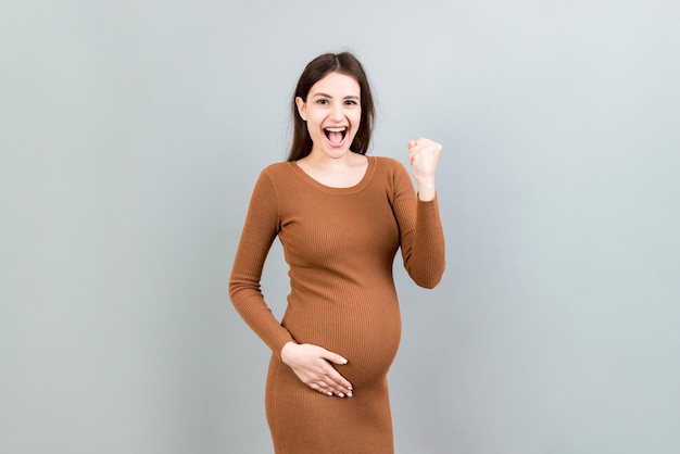 Joven hermosa mujer embarazada sobre fondo de color aislado celebrando sorprendida y sorprendida por el éxito con los brazos levantados y los ojos abiertos Concepto de ganador