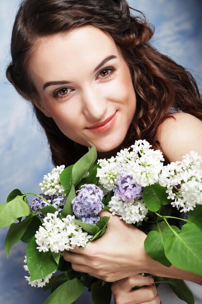 Foto joven y hermosa mujer con flores de lila