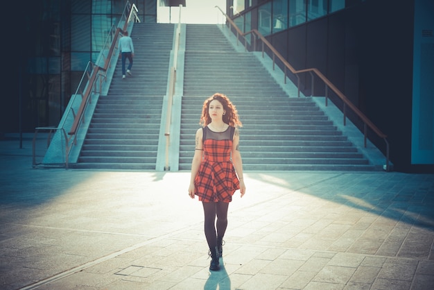 joven hermosa mujer hipster con pelo rizado rojo