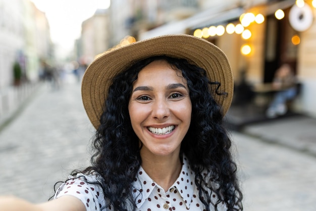 Joven hermosa mujer hispana sonriendo y mirando la cámara del teléfono el viajero usa la aplicación para teléfonos inteligentes