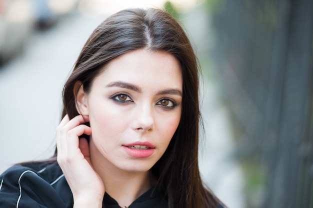 Joven hermosa mujer moderna al aire libre con maquillaje expresivo