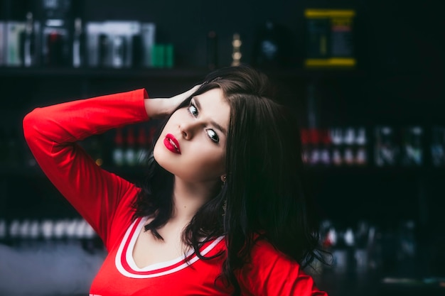 Joven hermosa mujer morena con maquillaje de moda en el bar