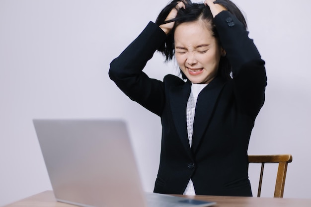 Joven hermosa mujer de negocios estresada por el trabajo de oficina Usa tus manos para alborotar tu cabello hasta que