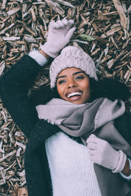 Joven hermosa mujer negra acostada sobre paces de madera