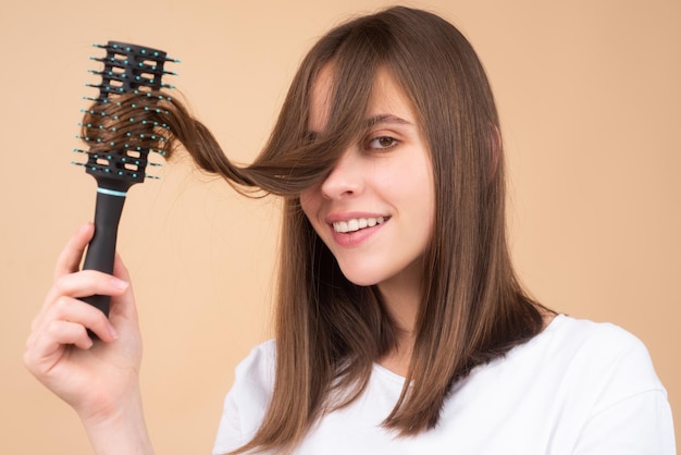 Joven hermosa mujer peinándose el cabello castaño cuidado del cabello hermosa mujer morena cepillando el cabello con h