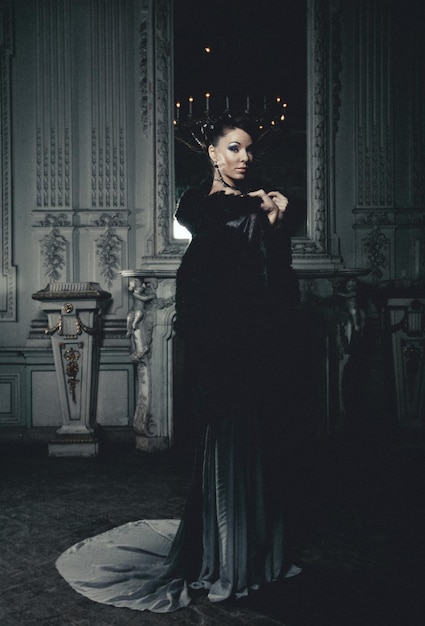 Foto joven y hermosa mujer de pie en la habitación del palacio