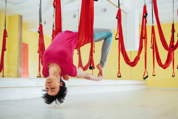 Joven hermosa mujer practicando yoga Volar con una hamaca, El concepto de salud mental y física.