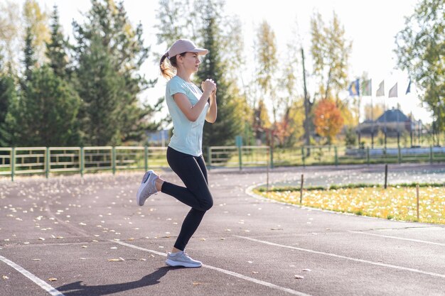 Foto una joven hermosa mujer en ropa deportiva practica deportes en un estadio local