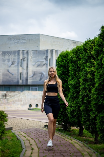 Joven hermosa mujer rubia deportiva con una camiseta negra y pantalones cortos deportivos ajustados negros