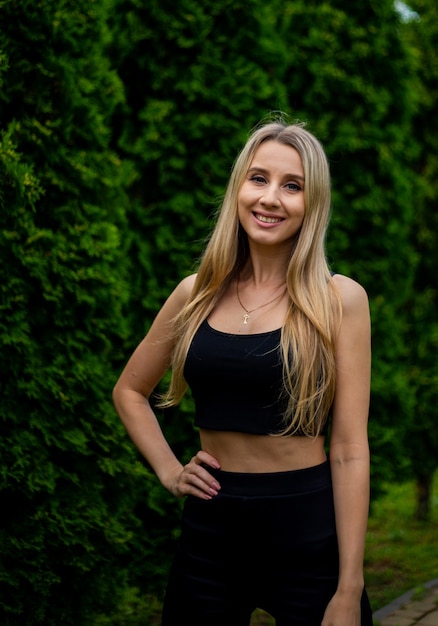 Joven hermosa mujer rubia deportiva con una camiseta negra y pantalones cortos deportivos ajustados negros