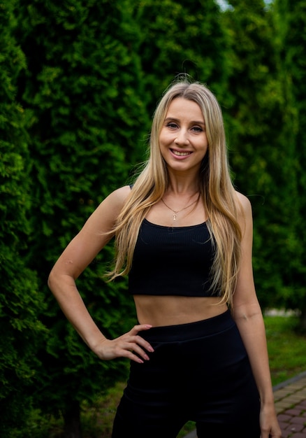 Joven hermosa mujer rubia deportiva con una camiseta negra y pantalones cortos deportivos ajustados negros