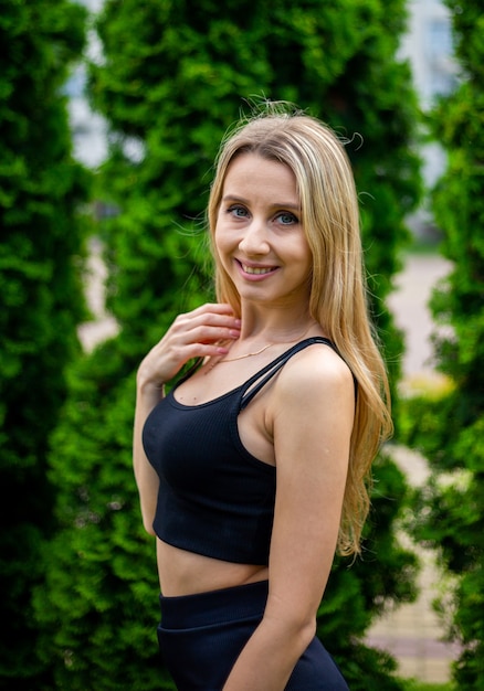 Joven hermosa mujer rubia deportiva con una camiseta negra y pantalones cortos deportivos ajustados negros