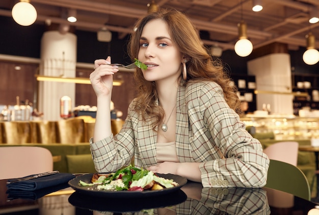 Foto joven hermosa mujer sonriente comiendo alimentos saludables