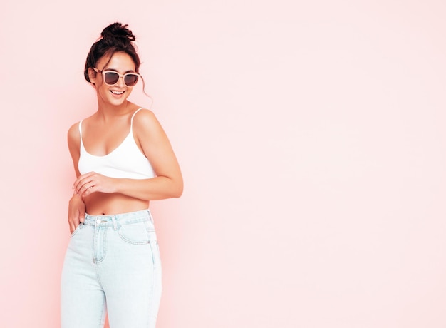 Joven hermosa mujer sonriente en ropa de verano de moda Mujer sexy despreocupada posando junto a la pared rosa en el estudio Modelo morena positiva divirtiéndose y volviéndose loca Alegre y feliz