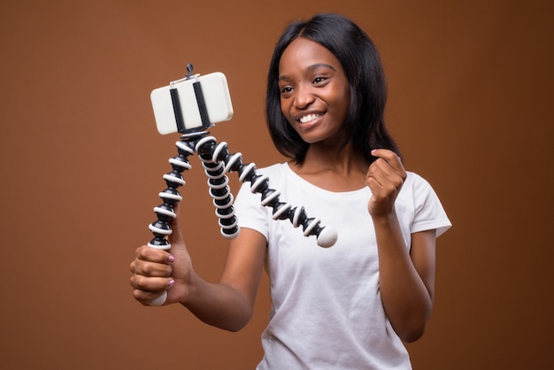 Joven hermosa mujer zulú africana sobre fondo marrón