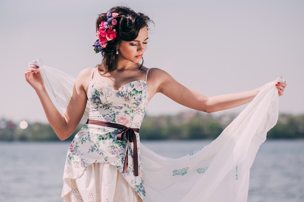 Joven hermosa niña camina por el lago