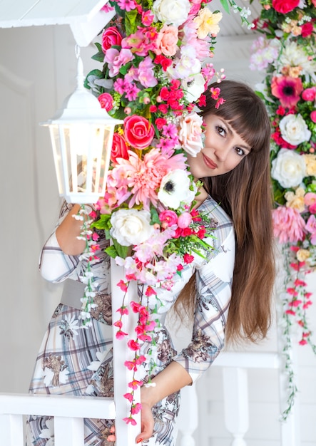 Joven hermosa niña se esconde entre las flores.