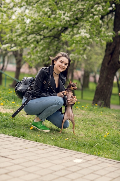 Joven hermosa niña jugando con perro al aire libre