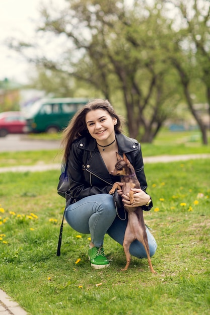 Joven hermosa niña jugando con perro al aire libre