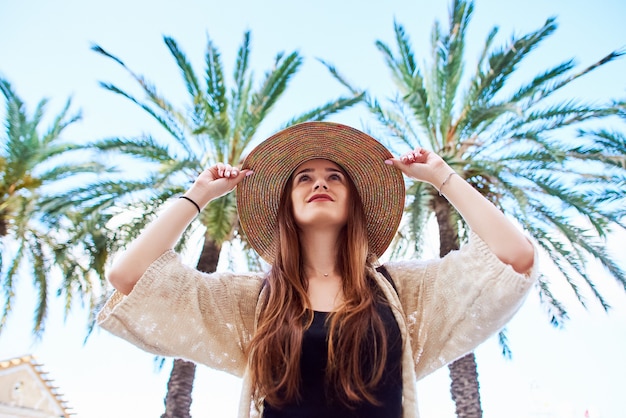 Joven hermosa niña en un sombrero de paja sonríe