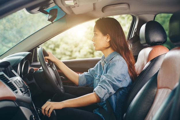 Joven hermosa niña sonriente conduciendo un coche