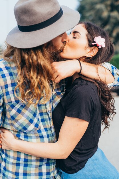 Joven hermosa pareja feliz abrazando al aire libre francés besos