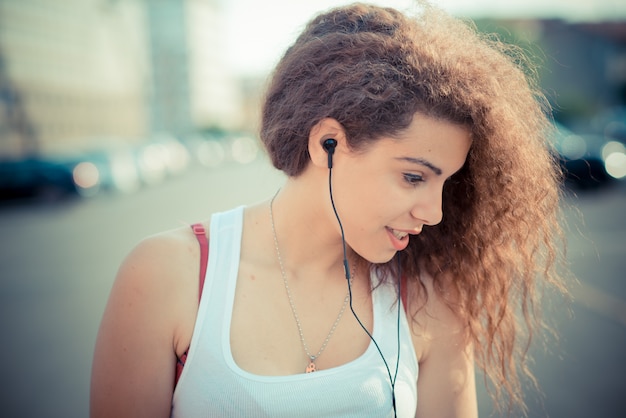 joven hermosa rizado largo cabello hipster mujer escuchando música