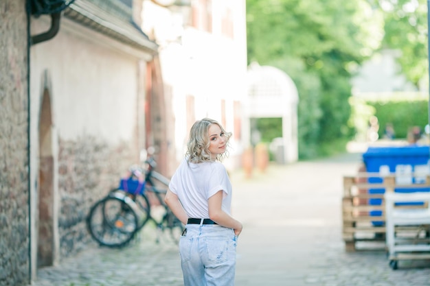 Joven hermosa rubia de ojos azules en el centro de una ciudad europea Retrato de un modelo elegante en ropa casual Juventud feliz