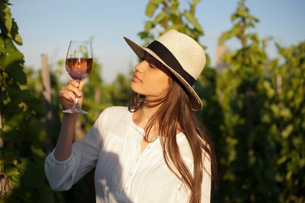 Una joven hermosa tomando vino.