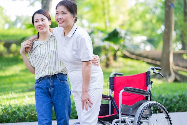 Joven hija asiática cuidando a su madre discapacitada