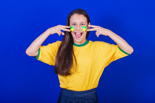 Joven hincha de fútbol de Brasil poniéndose pintura en la cara