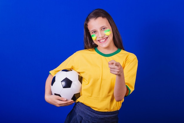 Joven hincha de fútbol de Brasil sosteniendo un balón de fútbol