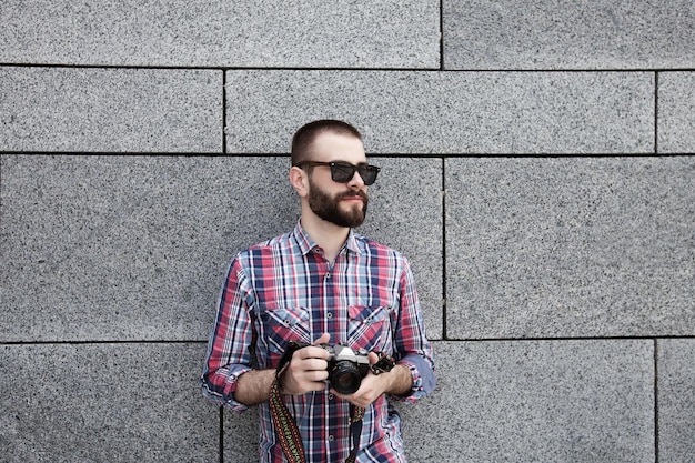 joven hipster con cámara de película retro vintage en las calles de la ciudad