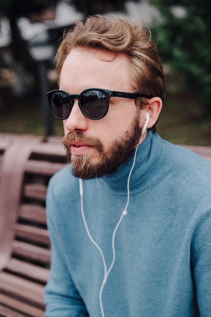 joven hipster hombre gay escuchando auriculares de música