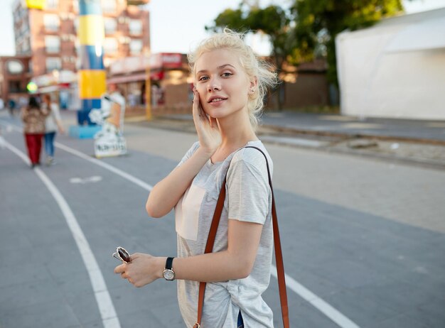 La joven hipster mirando a la cámara caminando sola por la calle