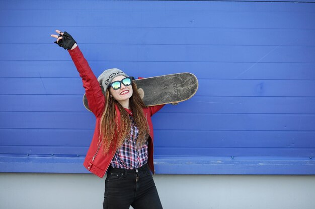 Foto una joven hipster está montando una patineta chicas amigas paseando por la ciudad con una patineta deportes de primavera en la calle con una patineta