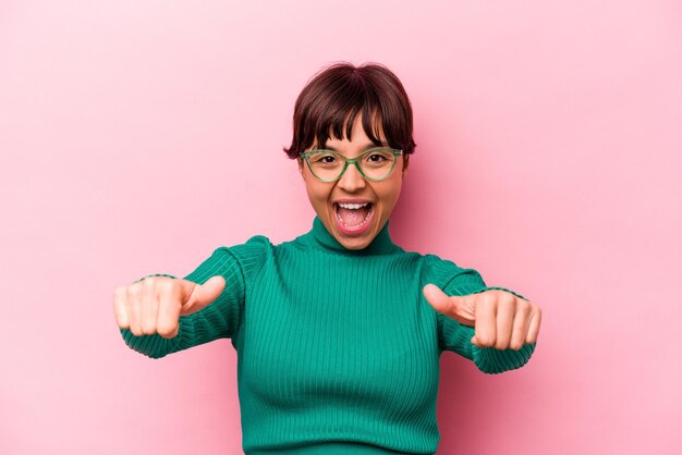 Joven hispana aislada de fondo rosa levantando ambos pulgares sonriendo y confiada