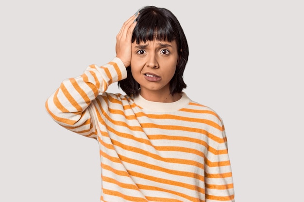 Foto una joven hispana con cabello negro corto en el estudio siendo conmocionada