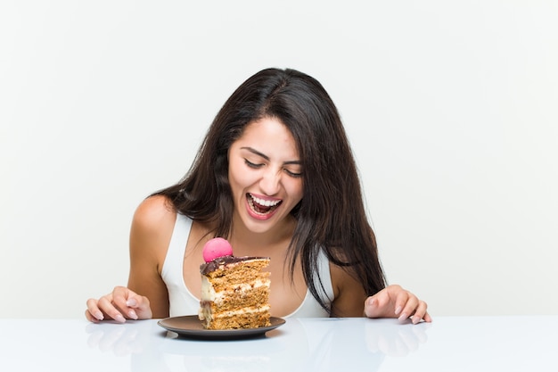 Joven hispana comiendo un pastel de zanahoria