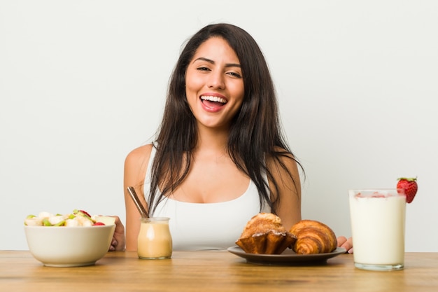 Joven hispana desayunando en la mesa