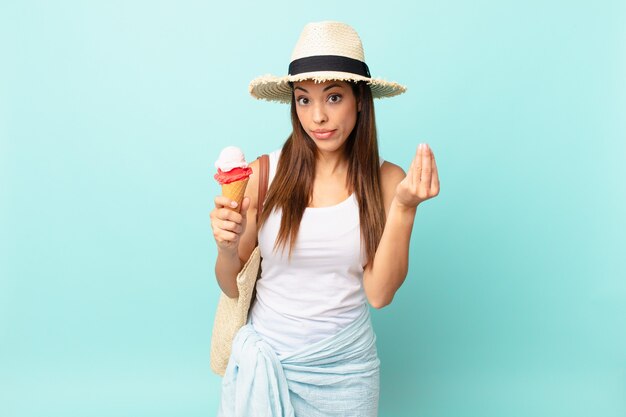 Joven hispana haciendo gesto de capice o dinero, diciéndole que pague y sosteniendo un helado. concepto sumergible