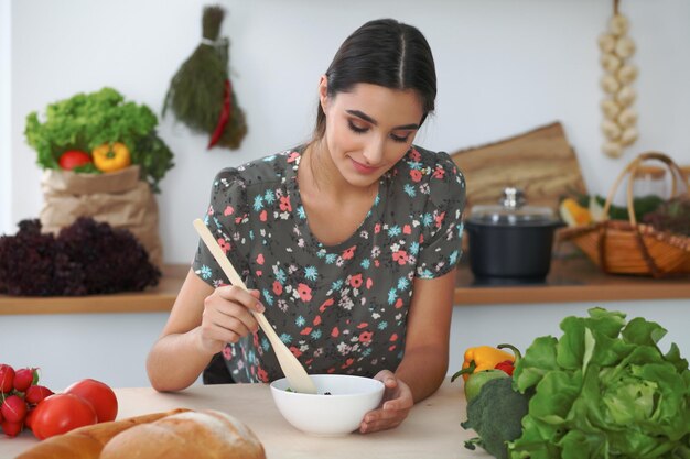 Joven hispana o estudiante cocinando en la cocina