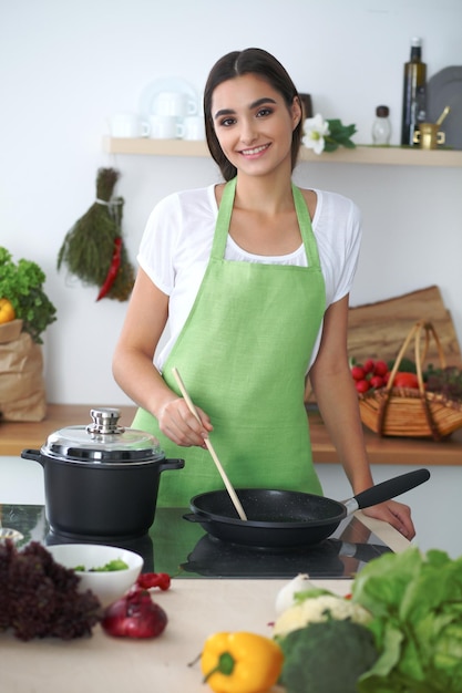 Joven hispana o estudiante cocinando en la cocina