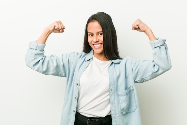 Joven hispana que muestra gesto de fuerza con los brazos, símbolo del poder femenino